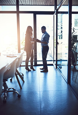 Buy stock photo Business people or professional managers talking about project management, discussing schedule and planning. Young businessman and businesswoman working together in a modern meeting boardroom