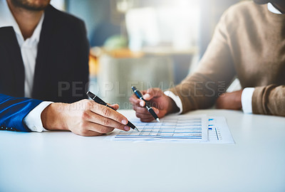 Buy stock photo Closeup shot of two unidentifiable businessmen going through some paperwork in an office