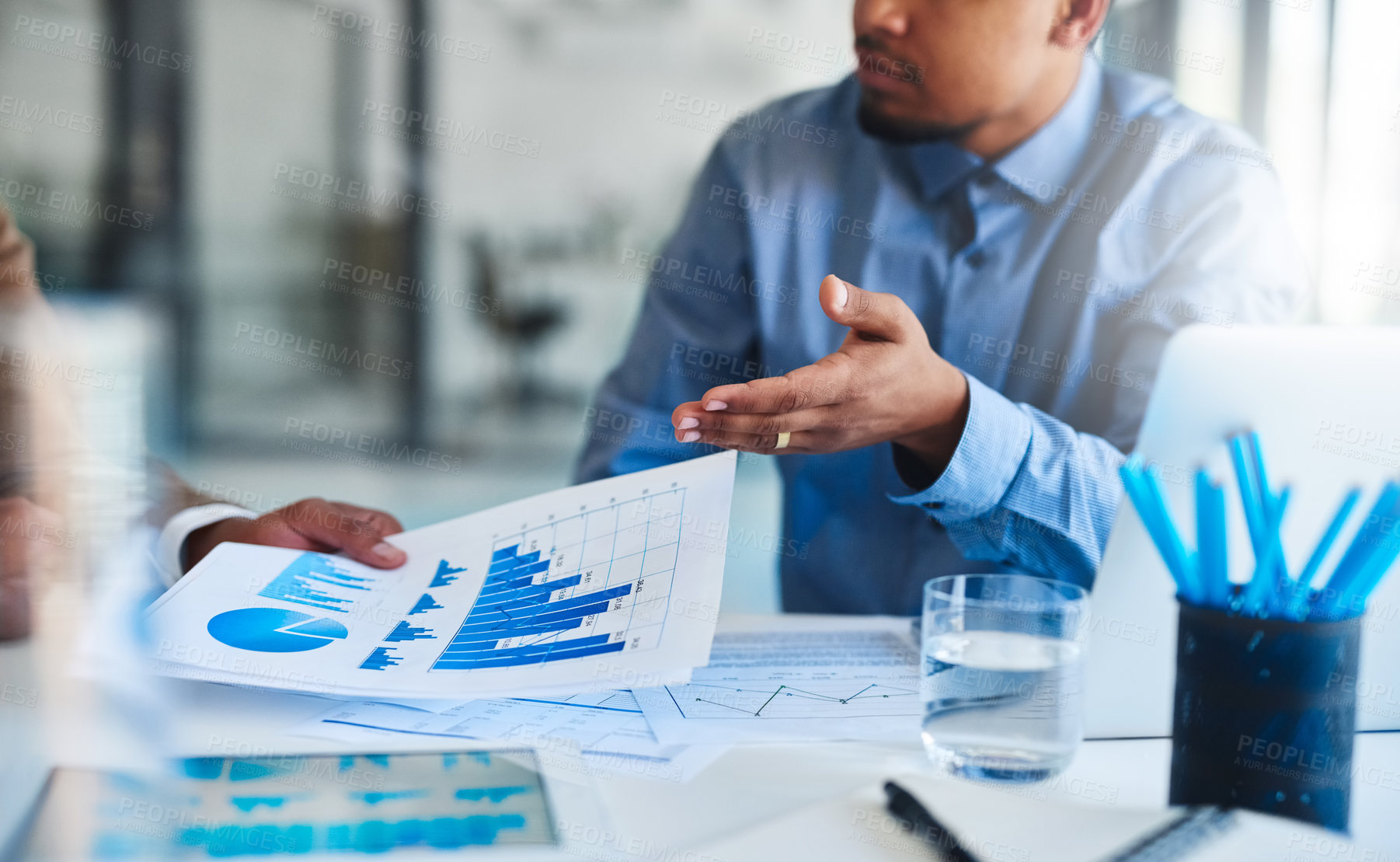 Buy stock photo Closeup shot of two unidentifiable businessmen going through some paperwork in an office