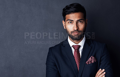 Buy stock photo Studio shot of a confident young businessman posing against a gray background