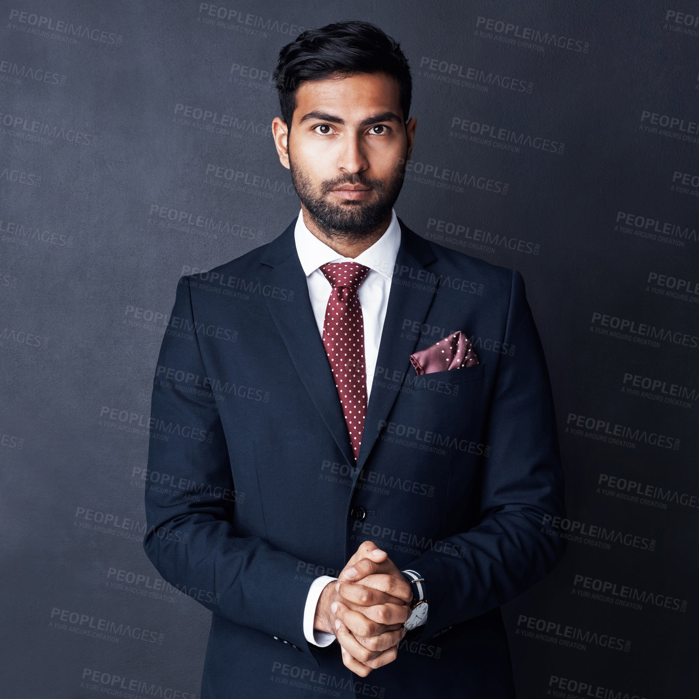 Buy stock photo Studio shot of a confident young businessman posing against a gray background