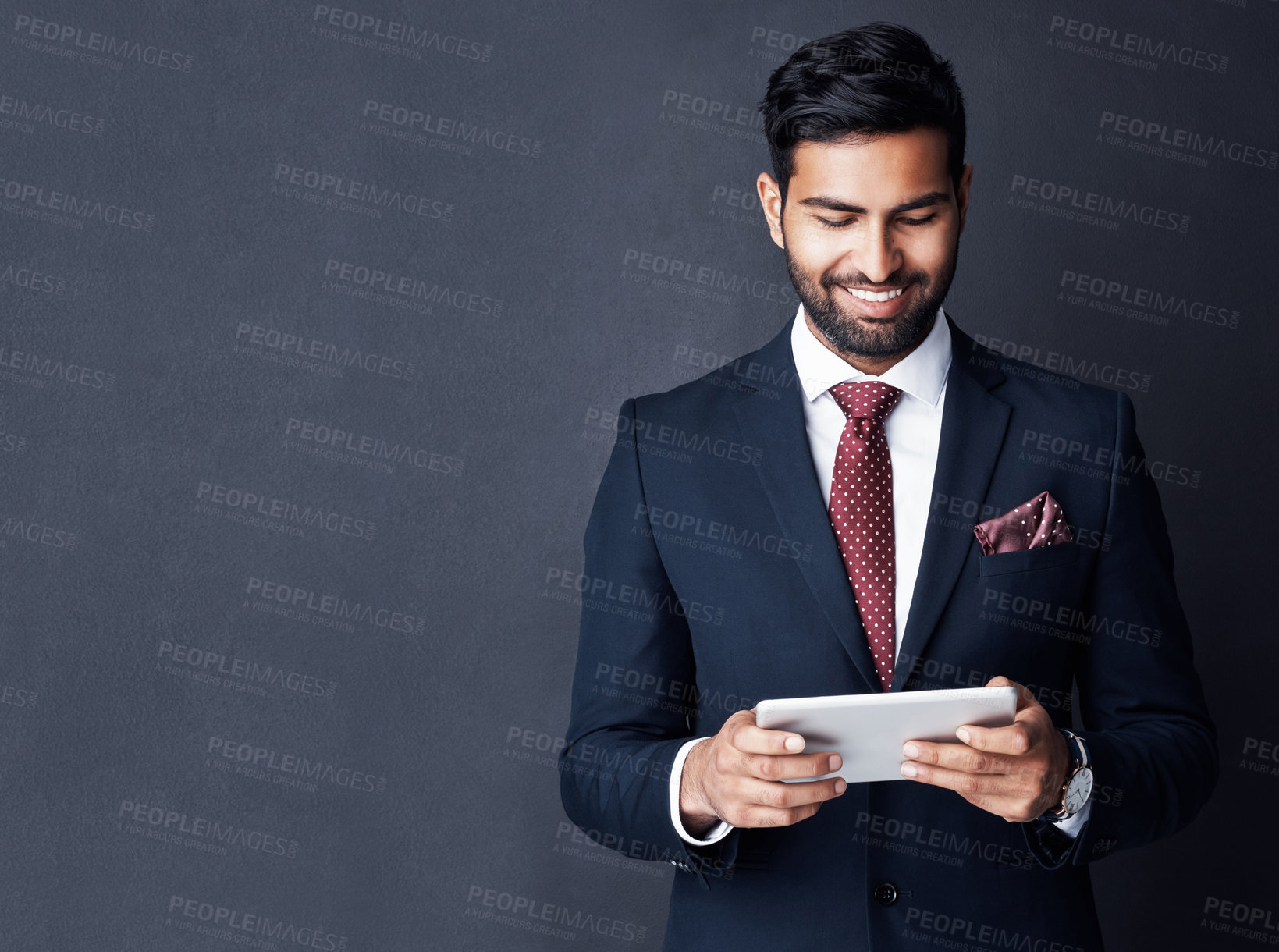 Buy stock photo Happy, business man and tablet on dark background in studio with mockup space for trading, planning and internet research. Corporate, indian male trader and smile for digital technology of online app