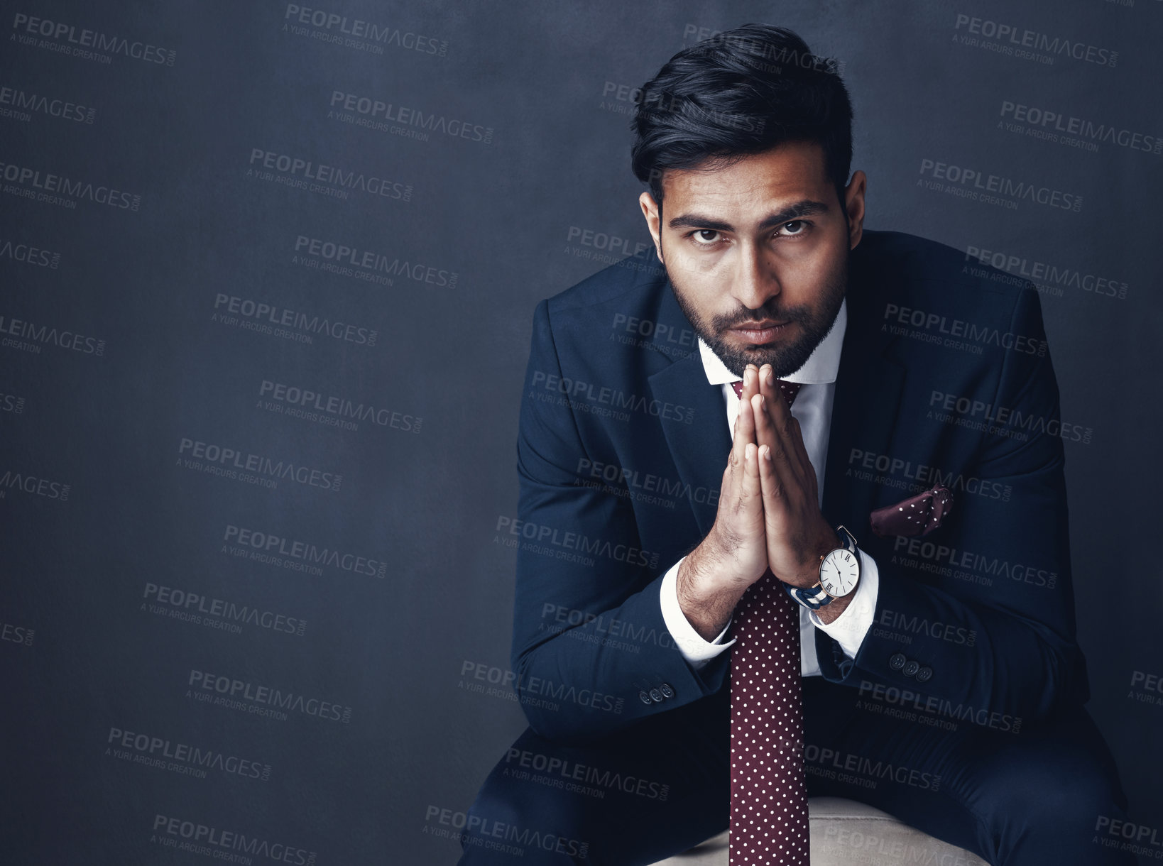 Buy stock photo Studio shot of a confident young businessman posing against a gray background