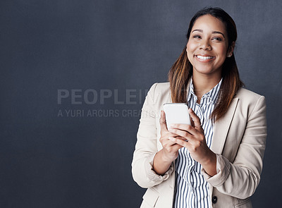 Buy stock photo Business woman, phone and smile in studio with mock up space, texting and thinking by gray background. Person, smartphone and excited with mobile app for good news, notification or announcement