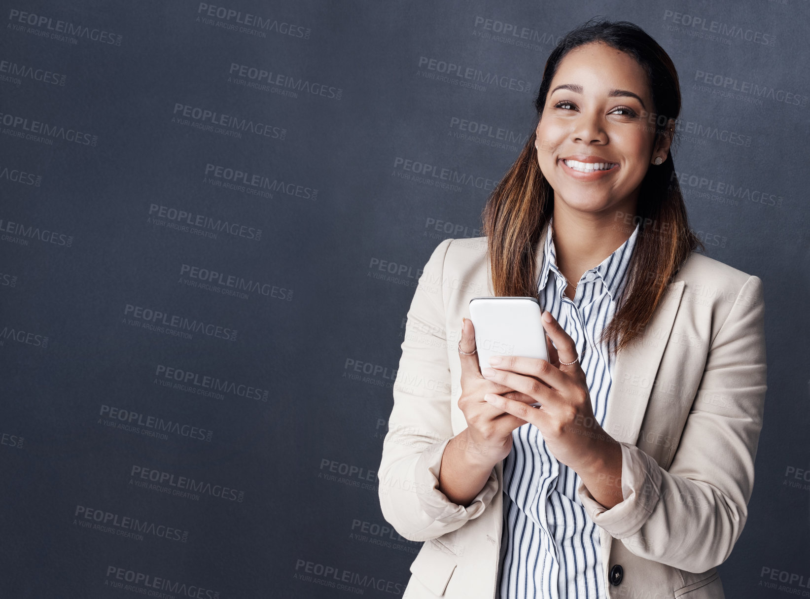 Buy stock photo Business woman, phone and smile in studio with mock up space, texting and thinking by gray background. Person, smartphone and excited with mobile app for good news, notification or announcement