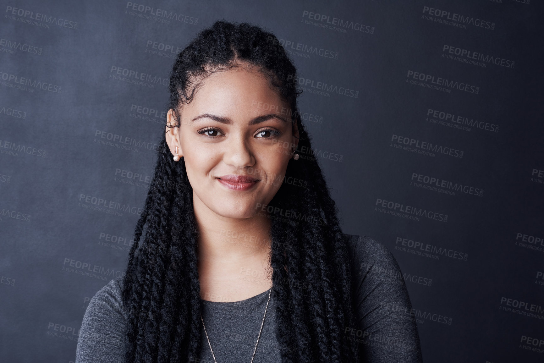 Buy stock photo Studio shot of a young woman posing against a gray background