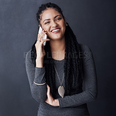 Buy stock photo Studio shot of a young woman talking on her cellphone against a grey background