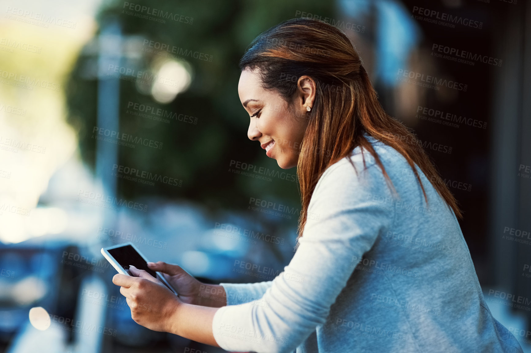 Buy stock photo Shot of a businesswoman using her tablet while standing outside on the balcony