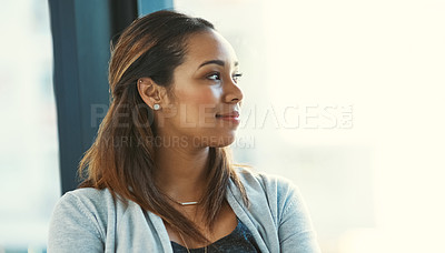 Buy stock photo Shot of an attractive young businesswoman looking out of her office window
