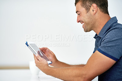 Buy stock photo Cropped shot of a young man working on a digital tablet against a white background