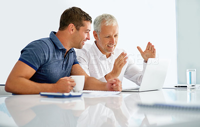 Buy stock photo Cropped shot of two businessmen working together on a laptop in an office