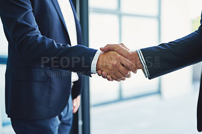 Buy stock photo Closeup shot of two unrecognisable businessmen shaking hands in an office