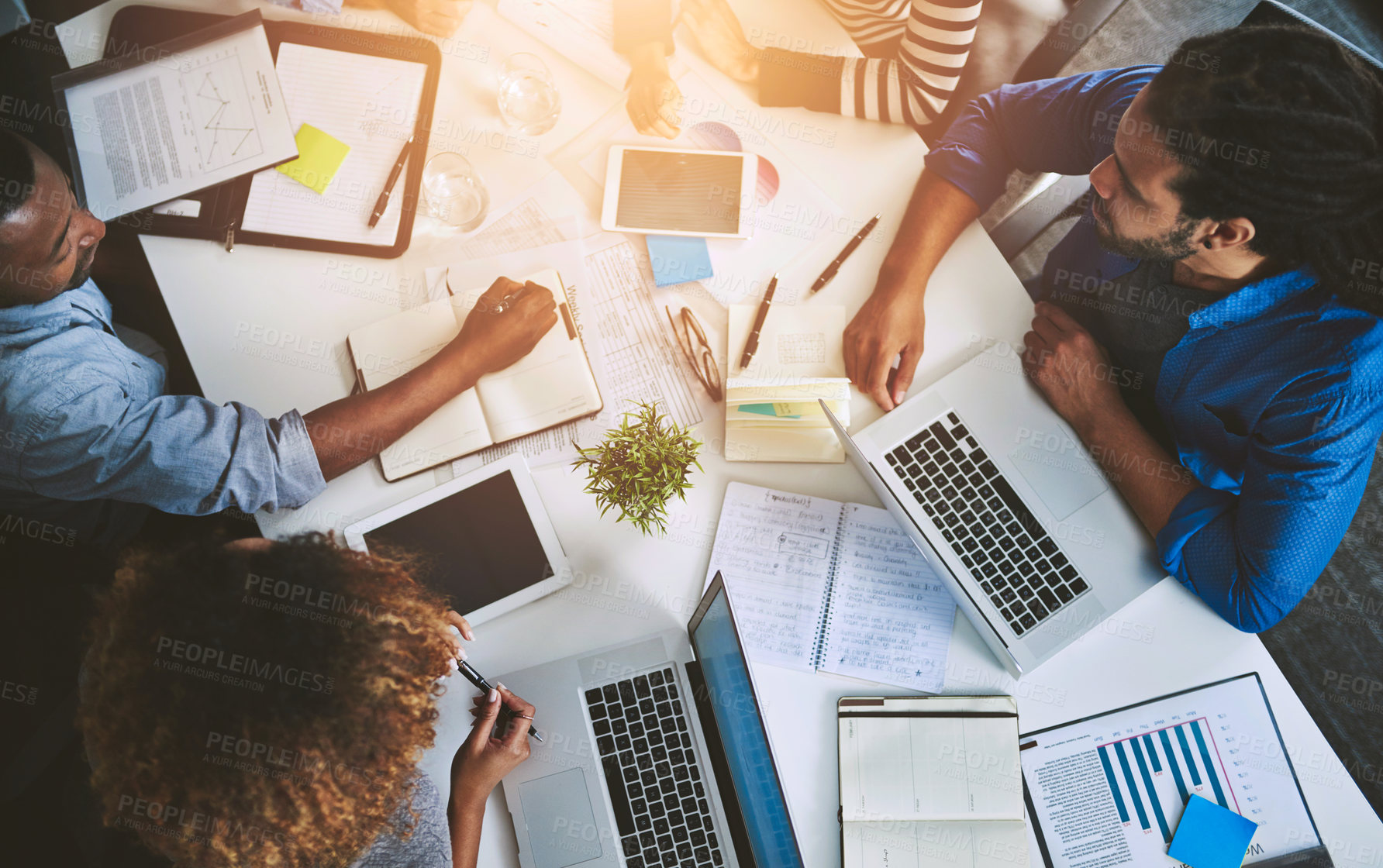 Buy stock photo Meeting, laptop and business people with notebook in boardroom for teamwork, idea or planning. Above, diversity and staff with book for report, discussion or deadline at printing firm with lens flare