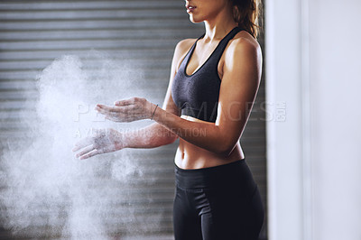 Buy stock photo Cropped shot of a sporty young woman dusting her hands with talcum powder
