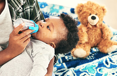 Buy stock photo Cropped shot of a mother giving her baby boy bottle