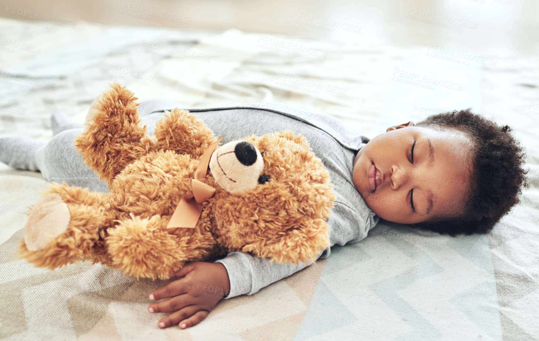 Buy stock photo Shot of a baby boy asleep with his teddy bear in his arm
