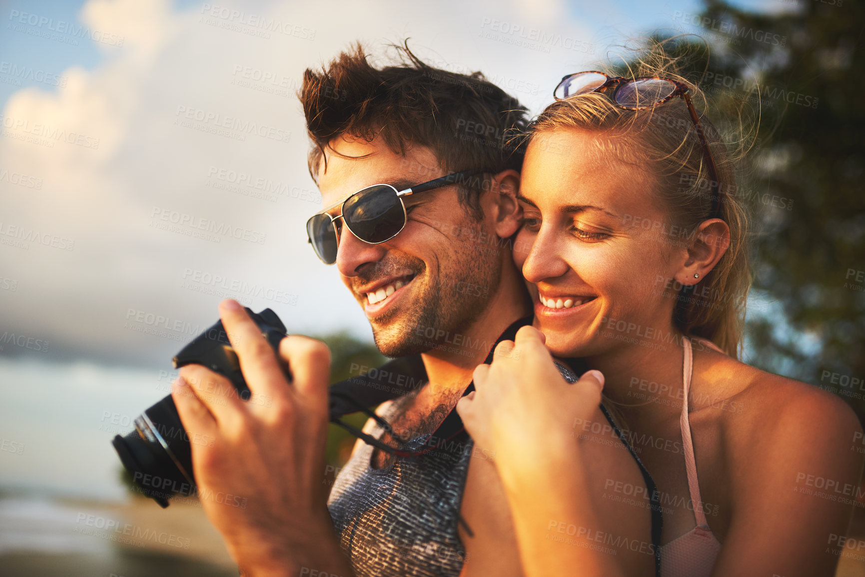 Buy stock photo Cropped shot of a young couple spending the day at the beach