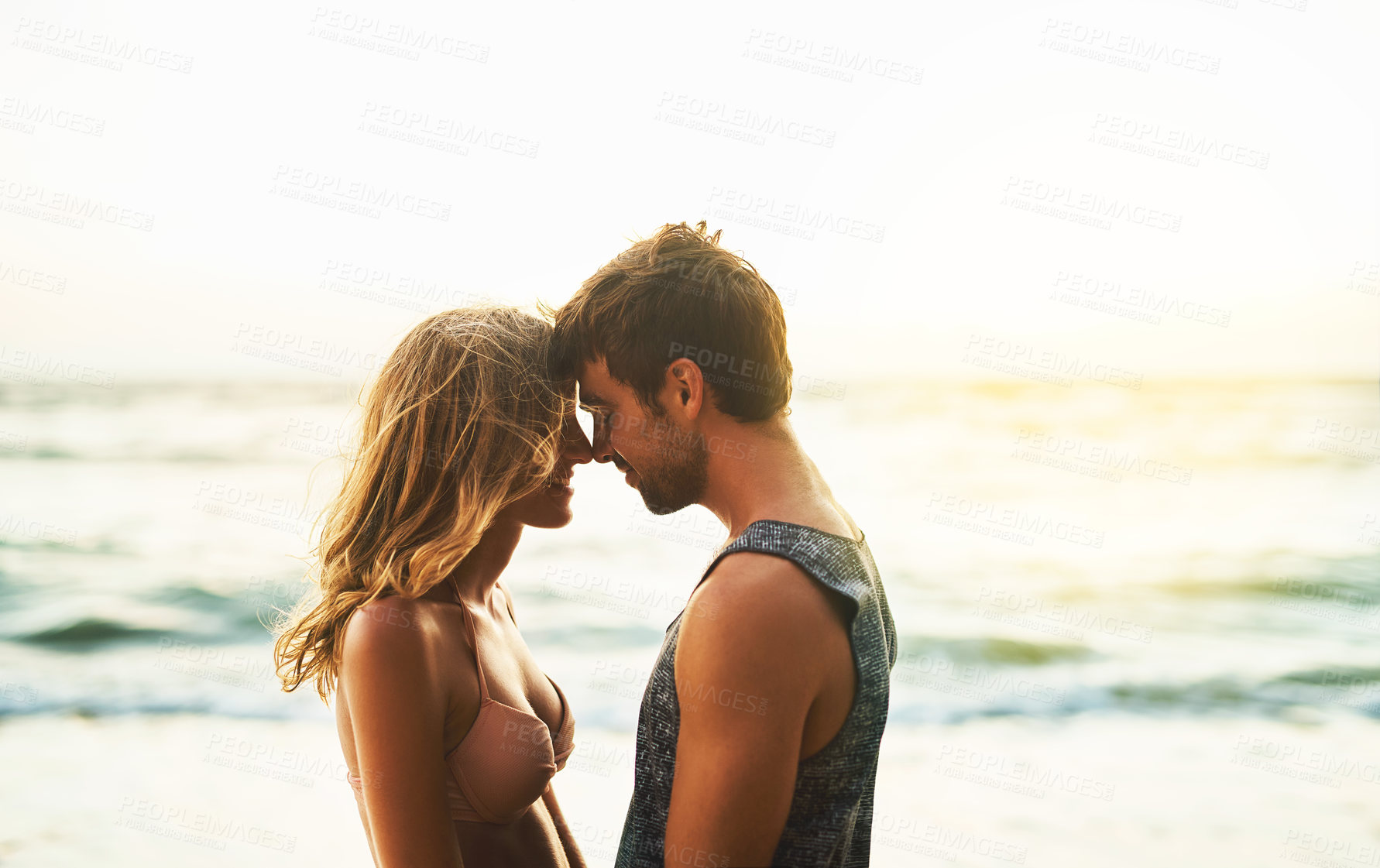 Buy stock photo Cropped shot of a young couple spending the day at the beach