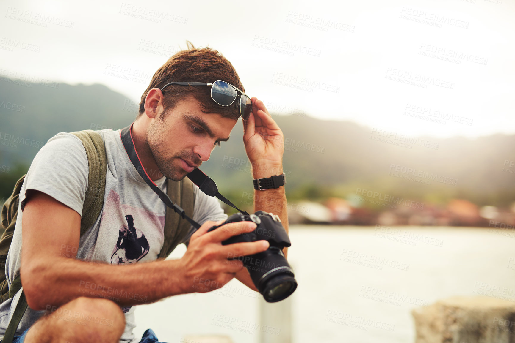 Buy stock photo Man, camera and travel photographer at mountain as photo journalist for tourism, hobby or water. Male person, pictures and outdoor creative at sea in Australia or blog equipment, view or professional