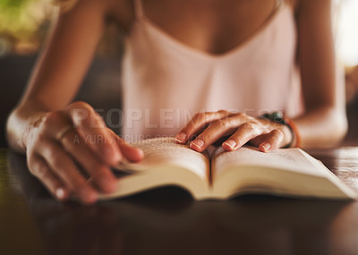 Buy stock photo Cropped shot of an unidentifiable woman reading a book