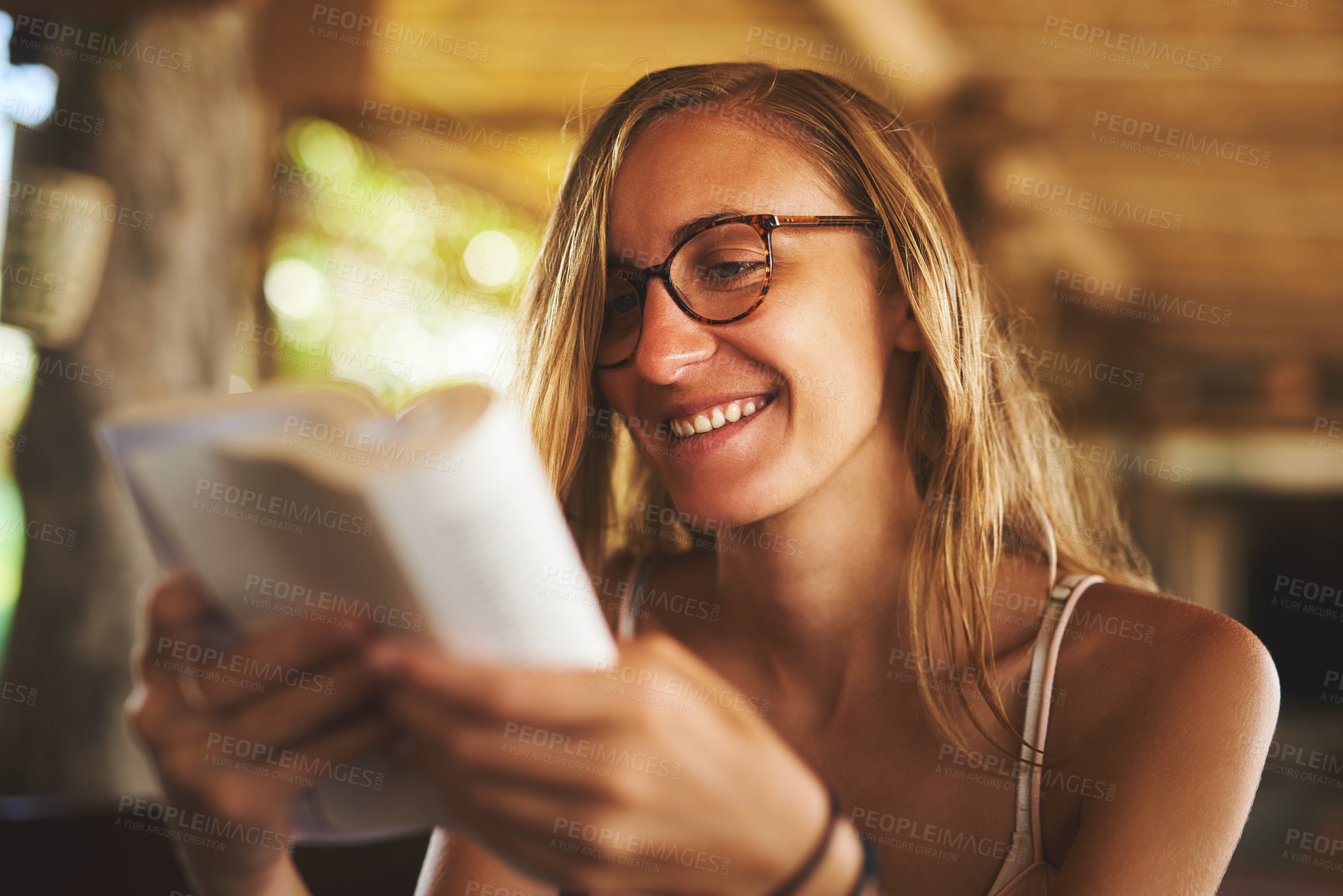 Buy stock photo Cropped shot of a young woman reading a book