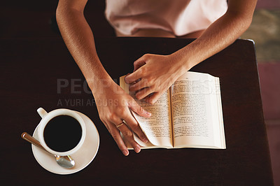 Buy stock photo High angle shot of an unidentifiable woman reading a book in a cafe