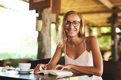 Buy stock photo Portrait of a young woman reading a book in a cafe