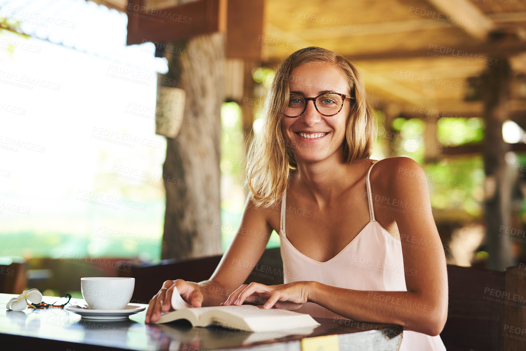 Buy stock photo Portrait, happy woman and reading book in cafe for story, knowledge and student in glasses for learning info in university. Face, coffee shop and girl studying novel on table at college in Germany