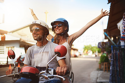 Buy stock photo Shot of young tourists enjoying a scooter ride around the city