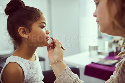 Buy stock photo Shot of a stylist applying makeup to a cute little girl in a dressing room