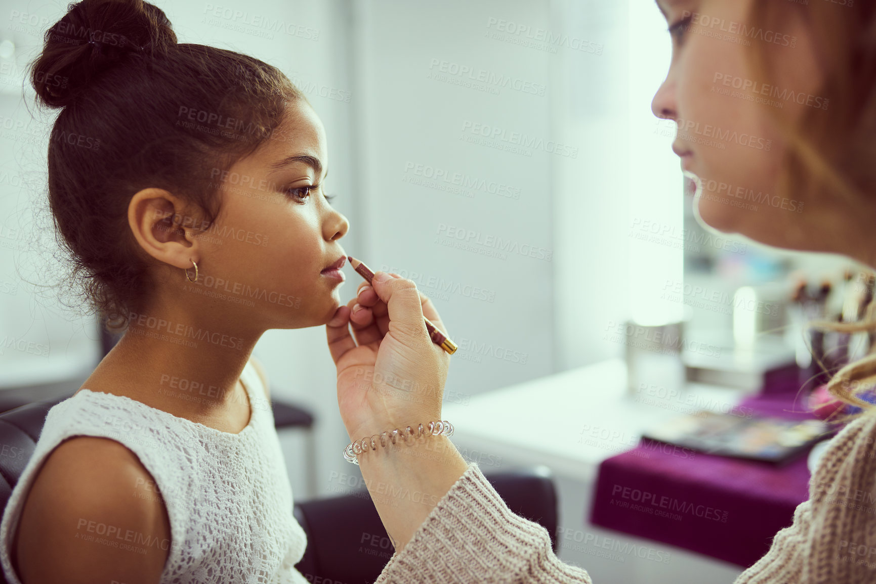 Buy stock photo Shot of a stylist applying makeup to a cute little girl in a dressing room