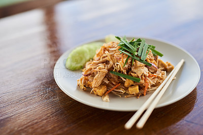 Buy stock photo Food, plate and Chinese cuisine with chopsticks to eat with chicken, noodles and spring onion dish. Lunch, pad thai and authentic stir fry for Asian culture on wooden table with herbs or spices.