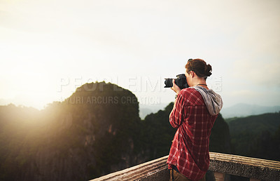 Buy stock photo Cropped shot of a young man taking photos of the view from the top of a mountain
