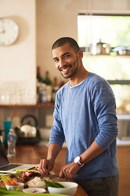 Buy stock photo Portrait of a happy young man preparing a healthy meal at home