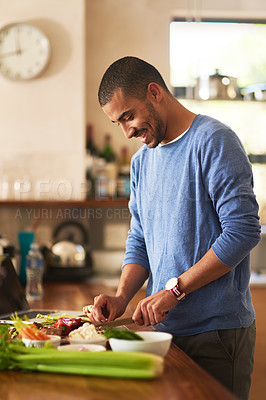 Buy stock photo Shot of a happy young man preparing a healthy snack at home