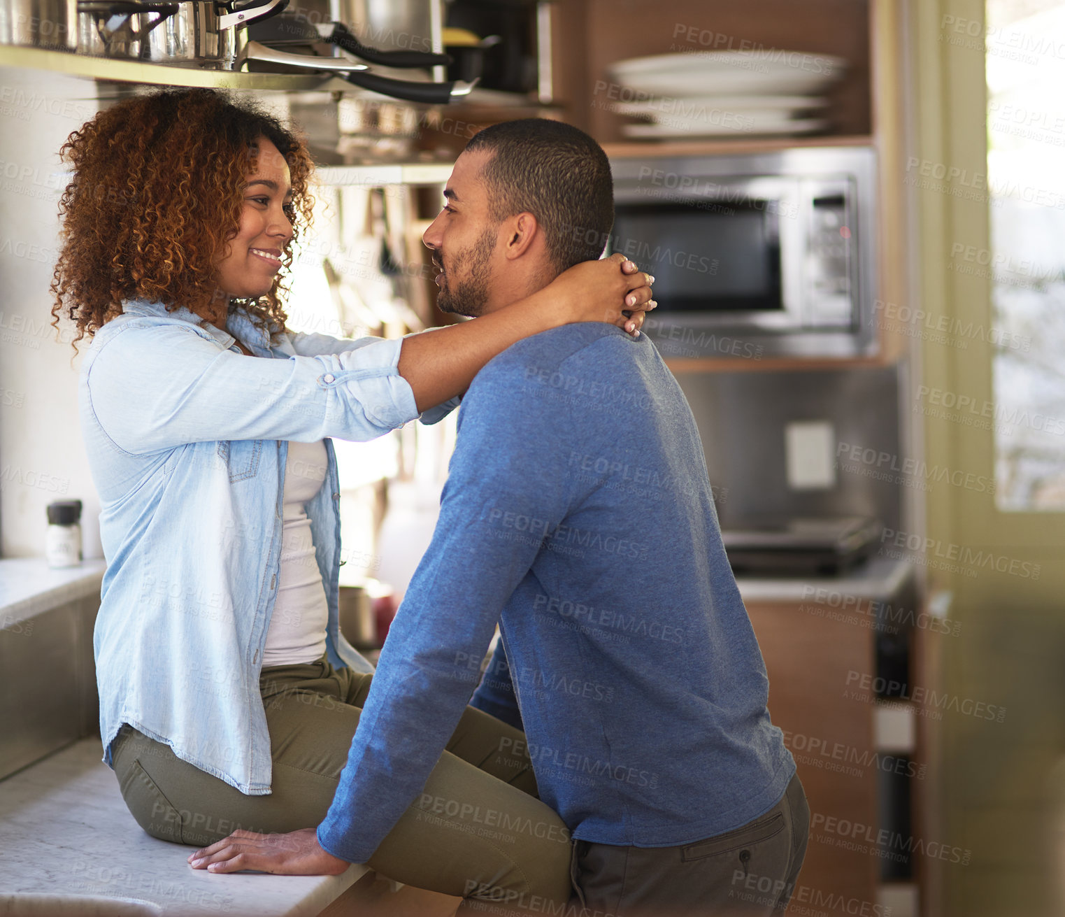 Buy stock photo Shot of a young couple sharing a romantic moment in the kitchen