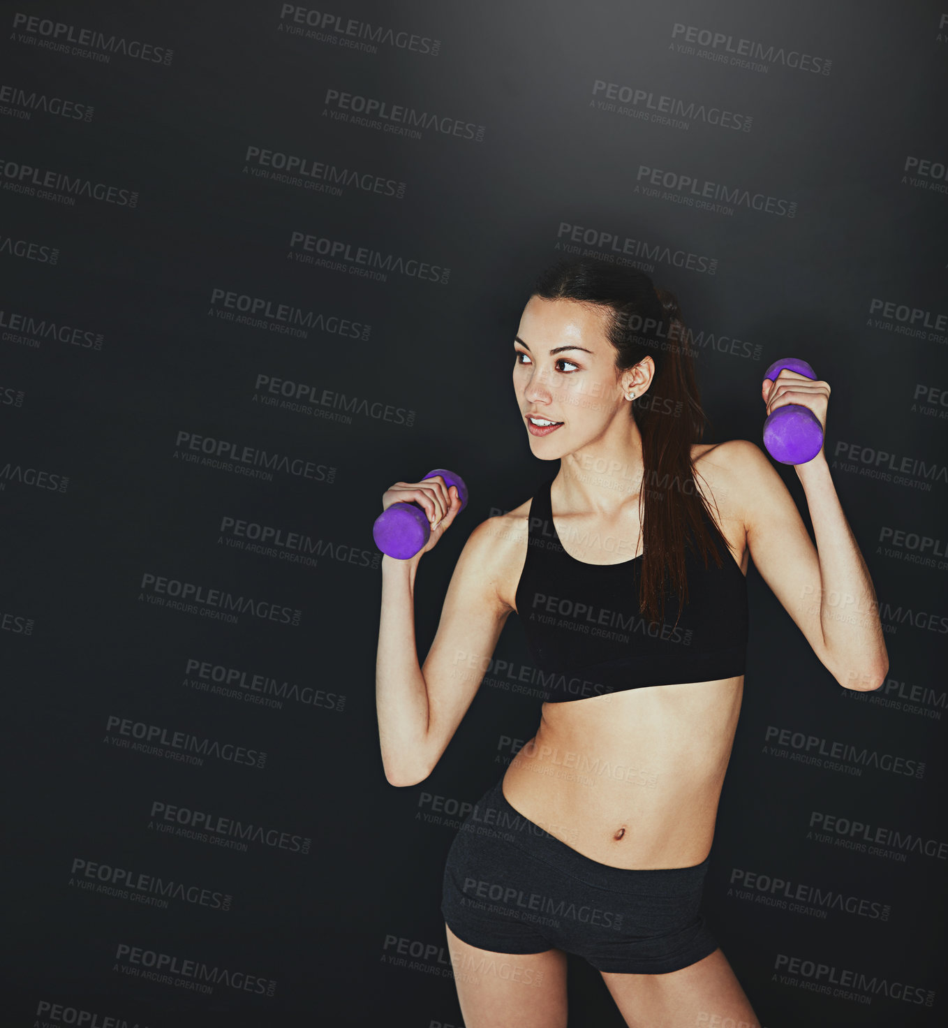 Buy stock photo Shot of a young woman working out with dumbbells