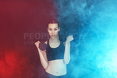 Buy stock photo Shot of a young woman working out with dumbbells