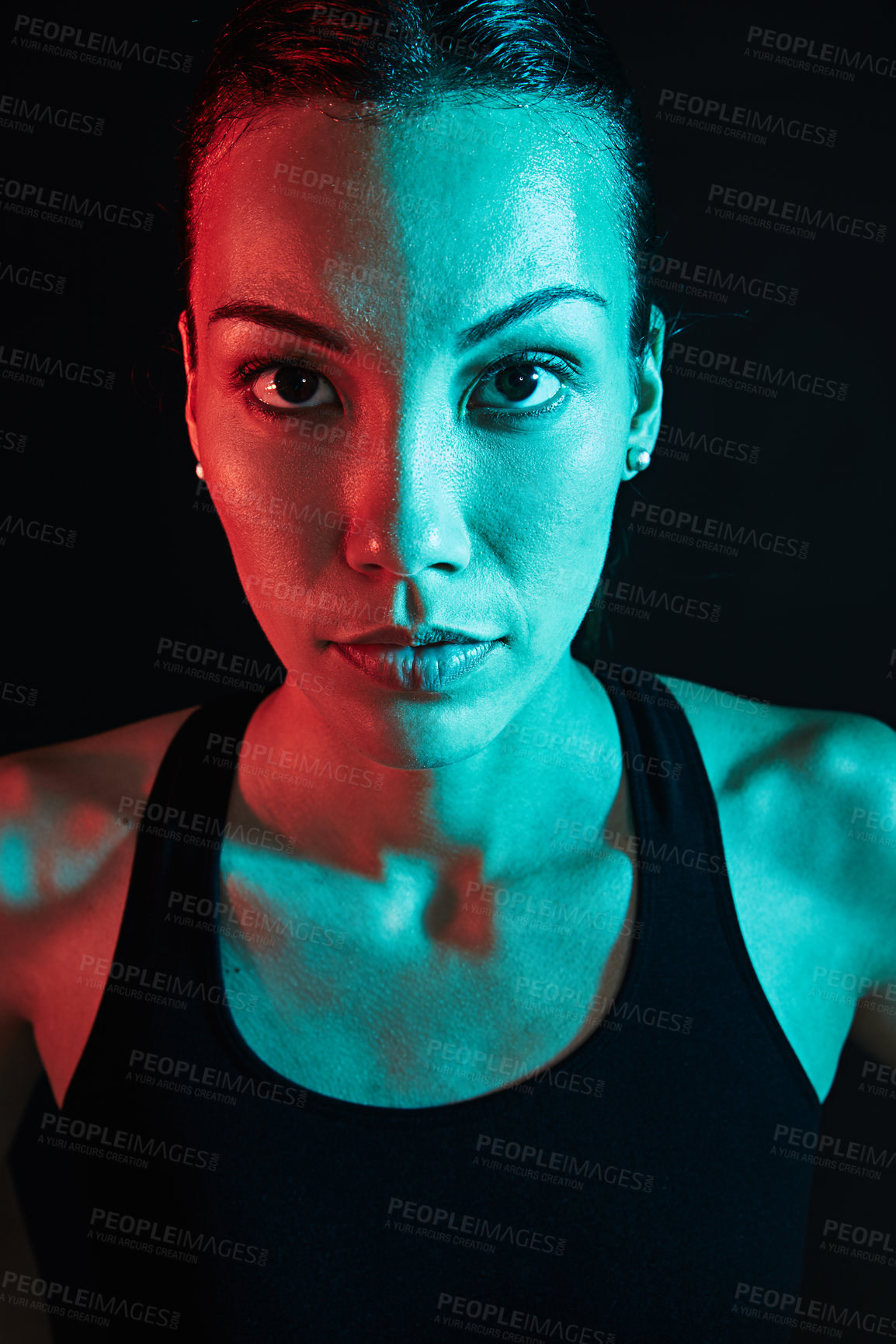 Buy stock photo Shot of a sporty young woman posing against a dark background