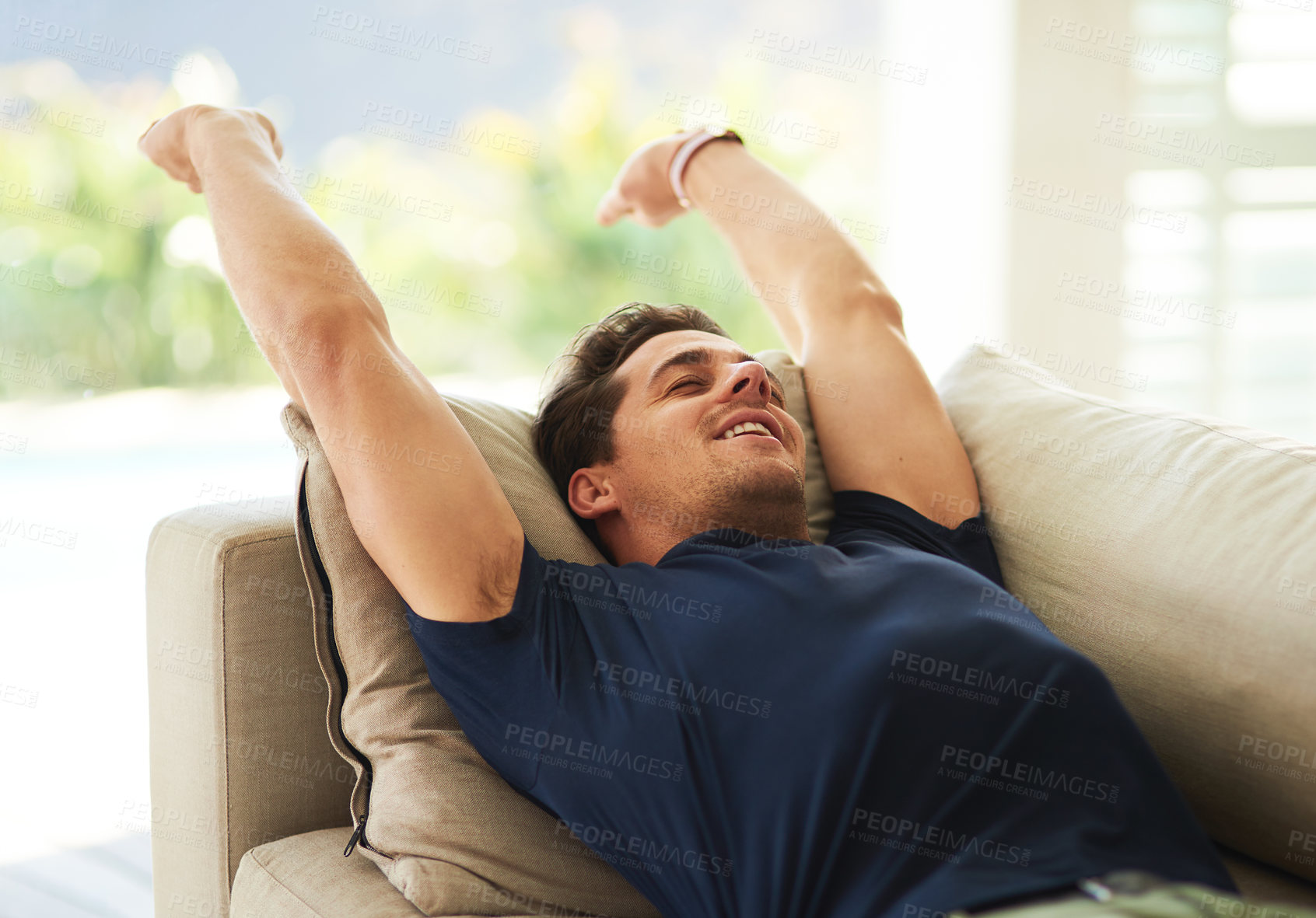 Buy stock photo Cropped shot of a handsome young man resting on his sofa at home