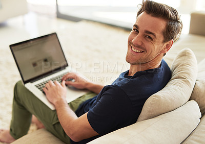 Buy stock photo High angle portrait of a handsome young man using his laptop at home