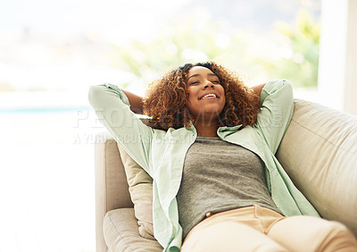 Buy stock photo Cropped shot of an attractive young woman resting on her sofa at home