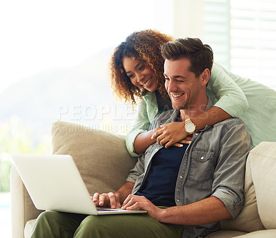 Buy stock photo Cropped shot of an affectionate young couple using a laptop in their home