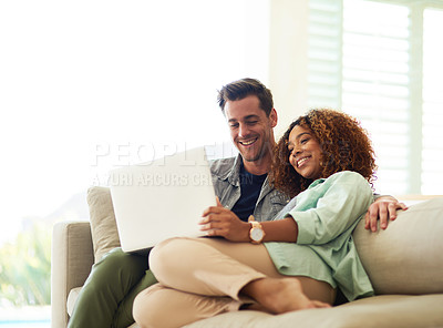 Buy stock photo Cropped shot of an affectionate young couple using a laptop in their home