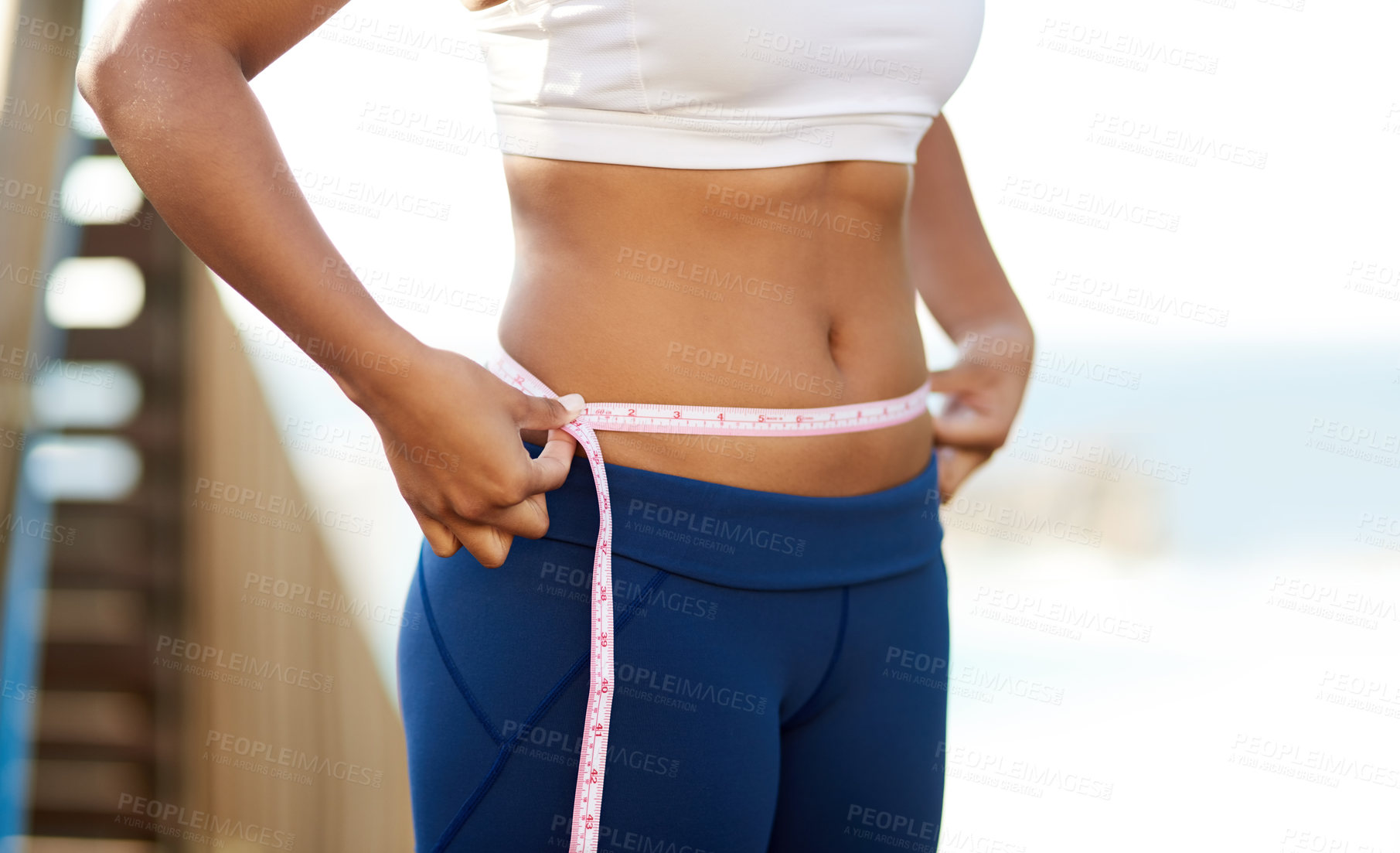 Buy stock photo Cropped shot of an unrecognizable young woman measuring her waistline