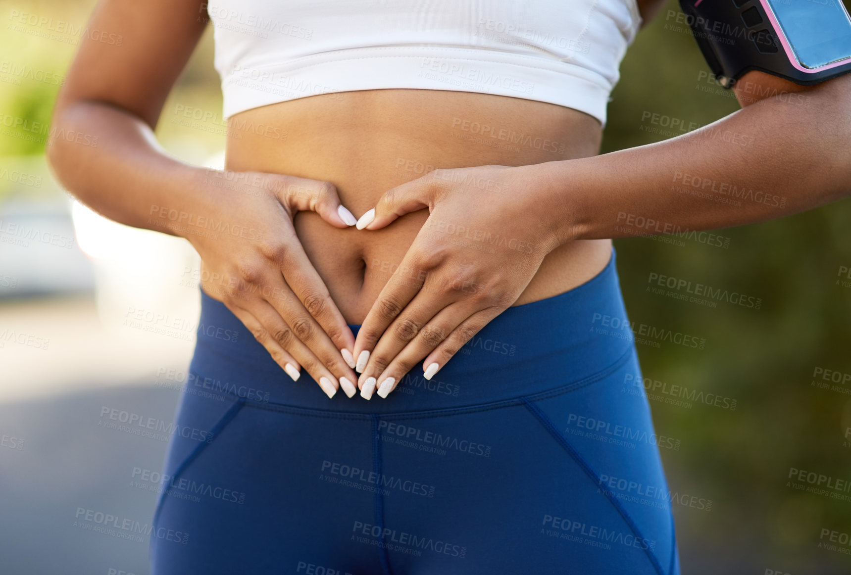 Buy stock photo Shot of an unrecognizable young woman making a heart shape on her belly