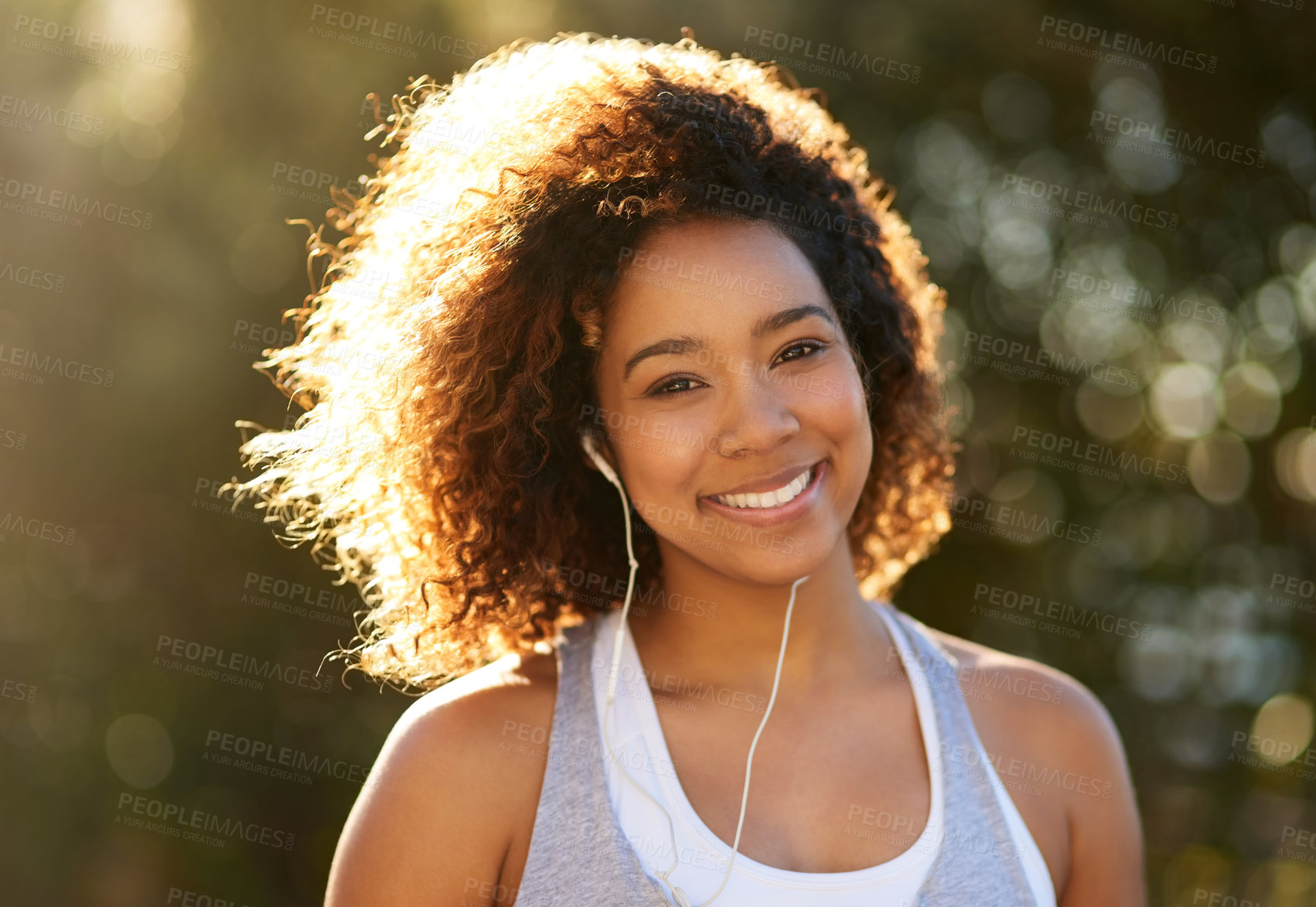 Buy stock photo Portrait of an attractive young woman listening to music while exercising outdoors