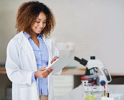 Buy stock photo Cropped shot of an attractive young woman capturing data on her tablet in the lab