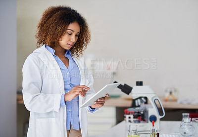 Buy stock photo Cropped shot of an attractive young woman capturing data on her tablet in the lab