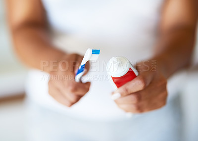Buy stock photo Cropped shot of a woman putting toothpaste on a toothbrush